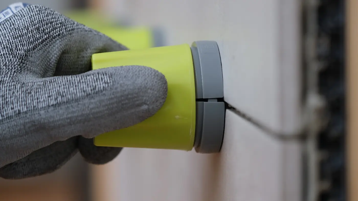 Hand mit Handschuh setzt die Leveltec Kappe an der Fuge auf